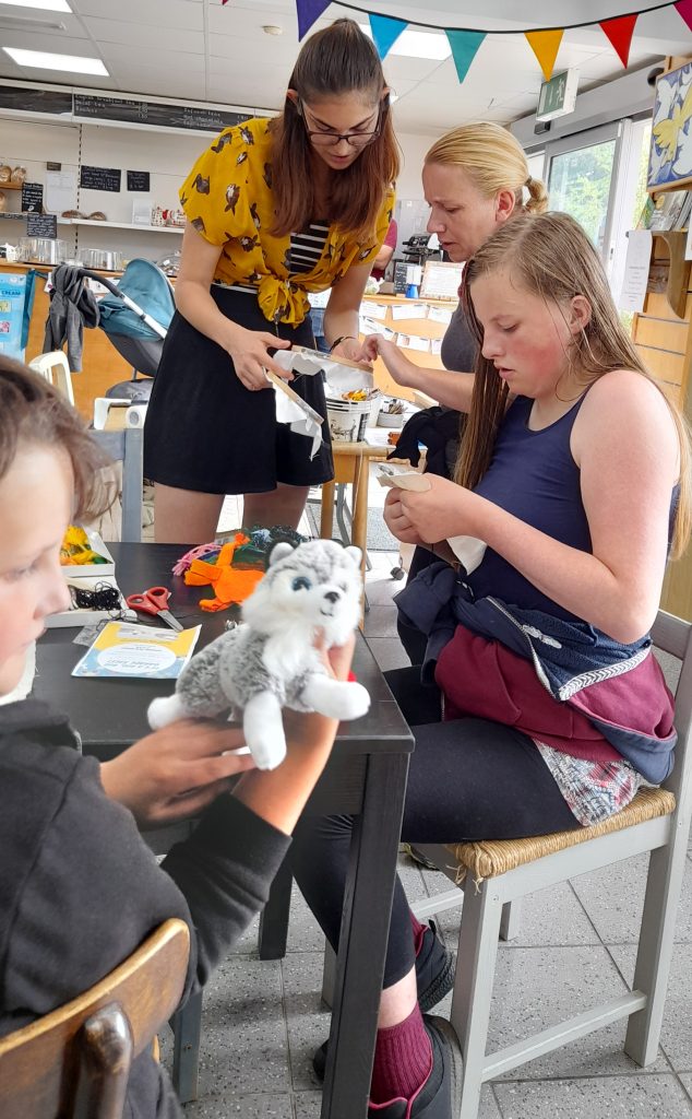 A group of teenagers around a table doing some craft activities
