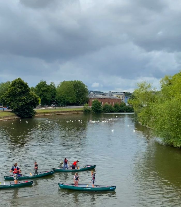 A group of people in canoes on the River Exe, near Exeter Quayside
